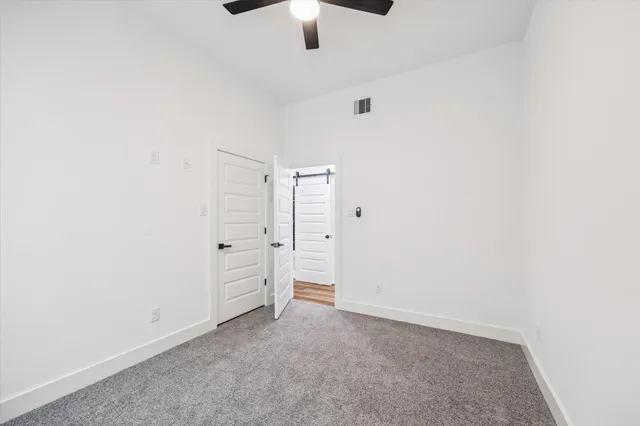 an empty room with closet and windows