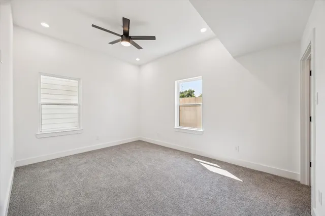 an empty room with a window and a ceiling fan