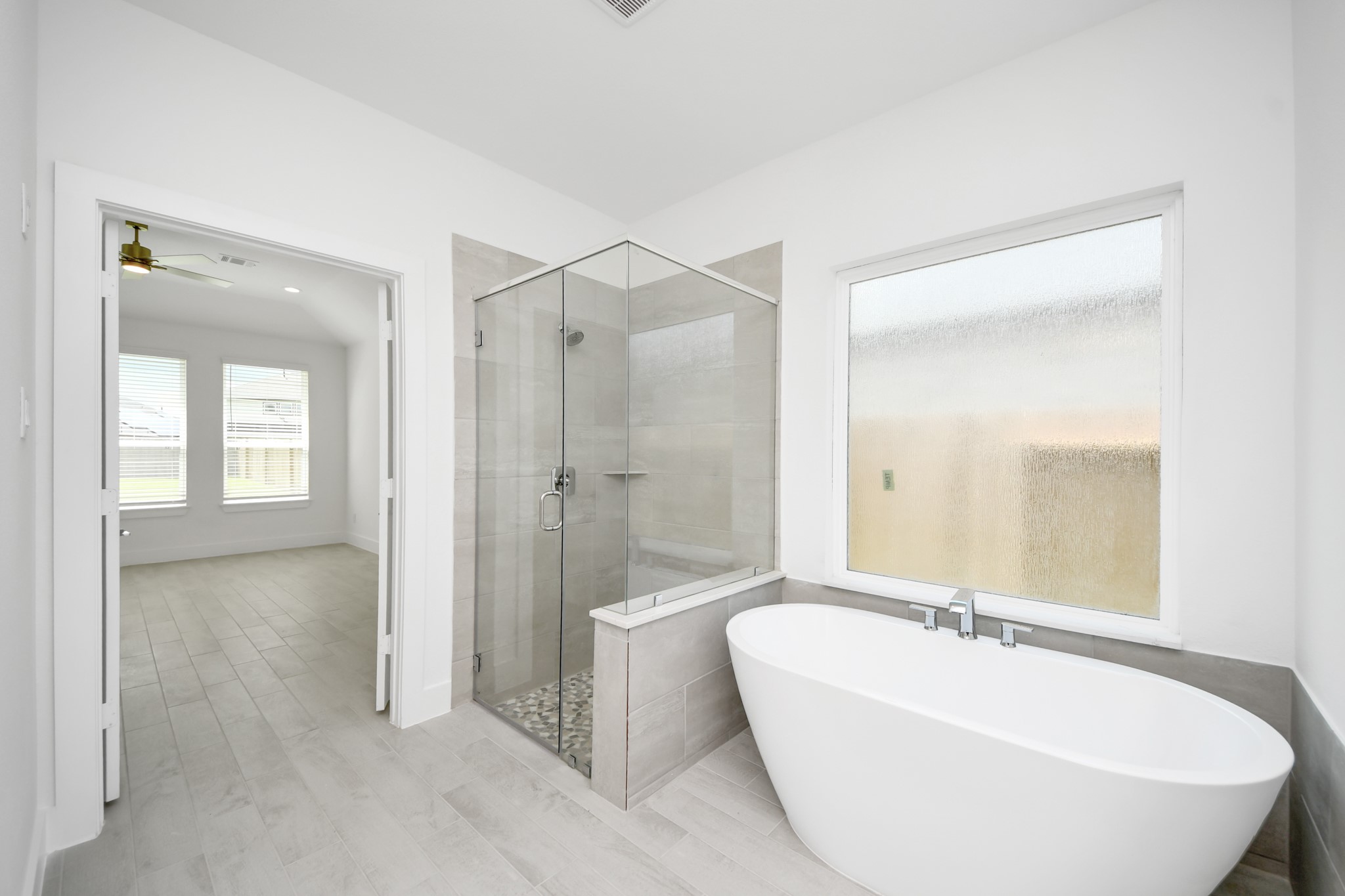 3102 Native Spg Drive Spring, TX 77373 - Photo 26 of 47 Indulge in a spa-like retreat within the confines of this primary bathroom. Delight in a spacious walk-in shower enveloped in stylish tile surround, unwind in a separate garden tub adorned with custom detailing.