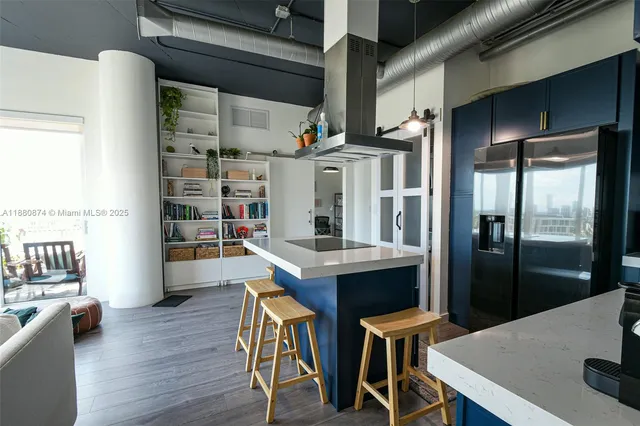 a kitchen with stainless steel appliances a dining table chairs and wooden floor