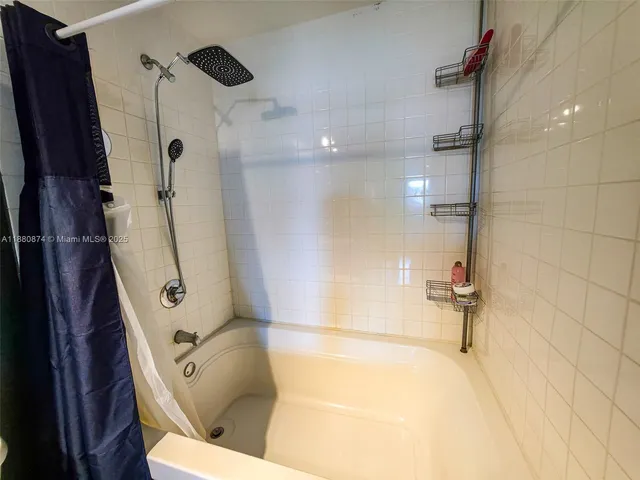 a bathroom with a tub a sink and glass door shower