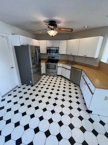 a kitchen with a checkered floor and white cabinets