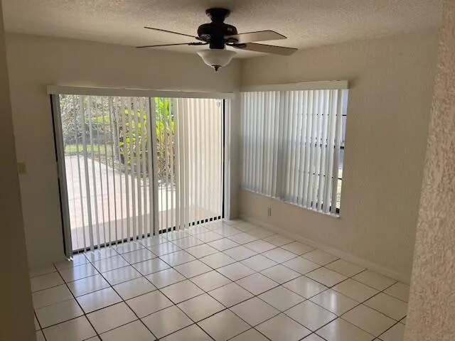 a view of a livingroom with a chandelier fan and windows