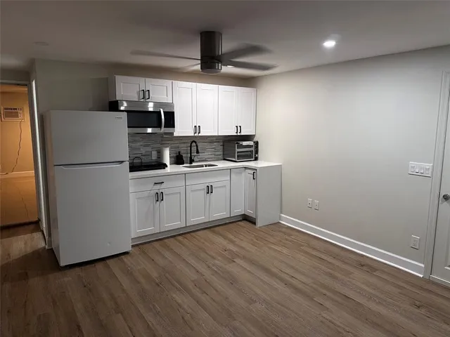 a kitchen with a refrigerator a sink and cabinets