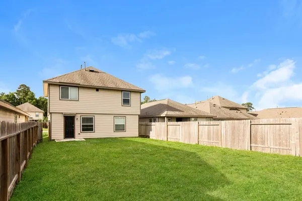 a view of a yard with wooden fence and a large tree