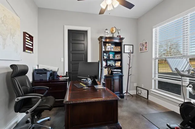 a view of a workspace with furniture and a window