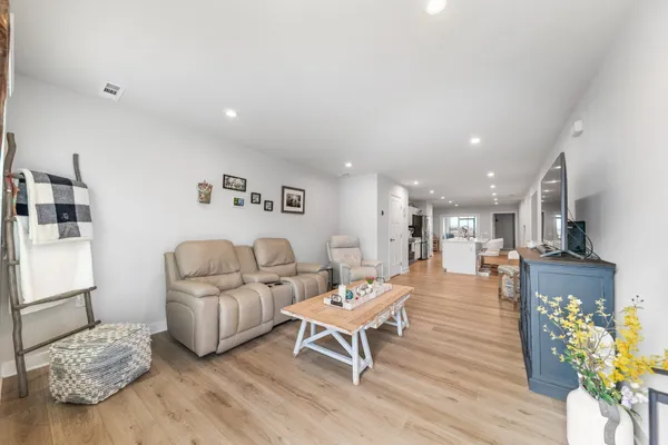 a living room with furniture and a wooden floor