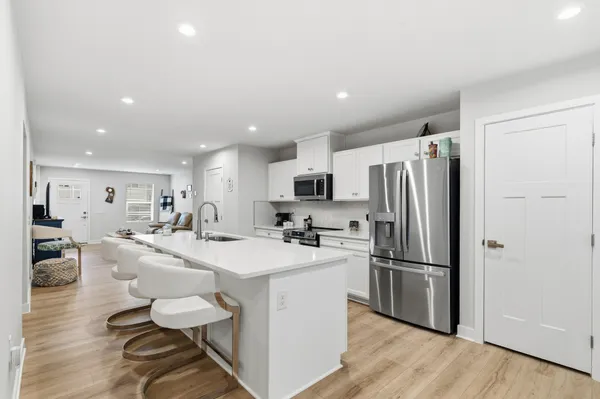 a kitchen with refrigerator and chairs