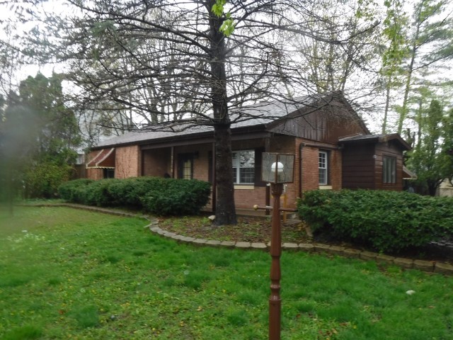 a view of a house with backyard and a tree