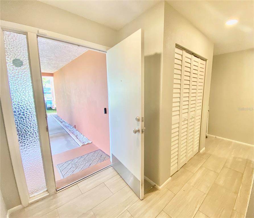 1632 Heather Place Palm Harbor, FL 34684 - Photo 4 of 39 a view of a hallway to an empty room with wooden floor and a bathroom