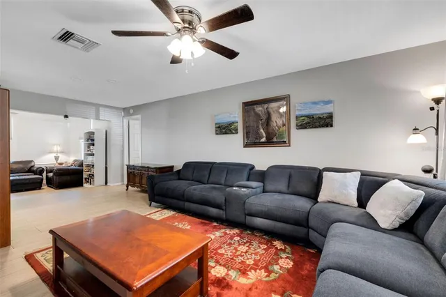 a living room with furniture a couch and a ceiling fan