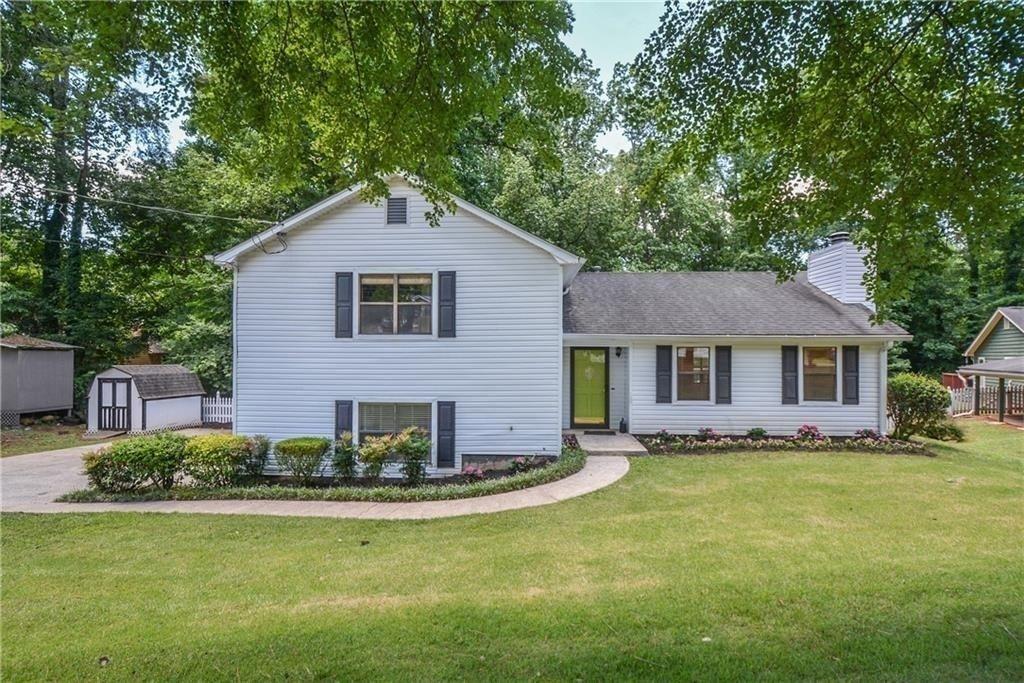 a front view of a house with a yard and trees