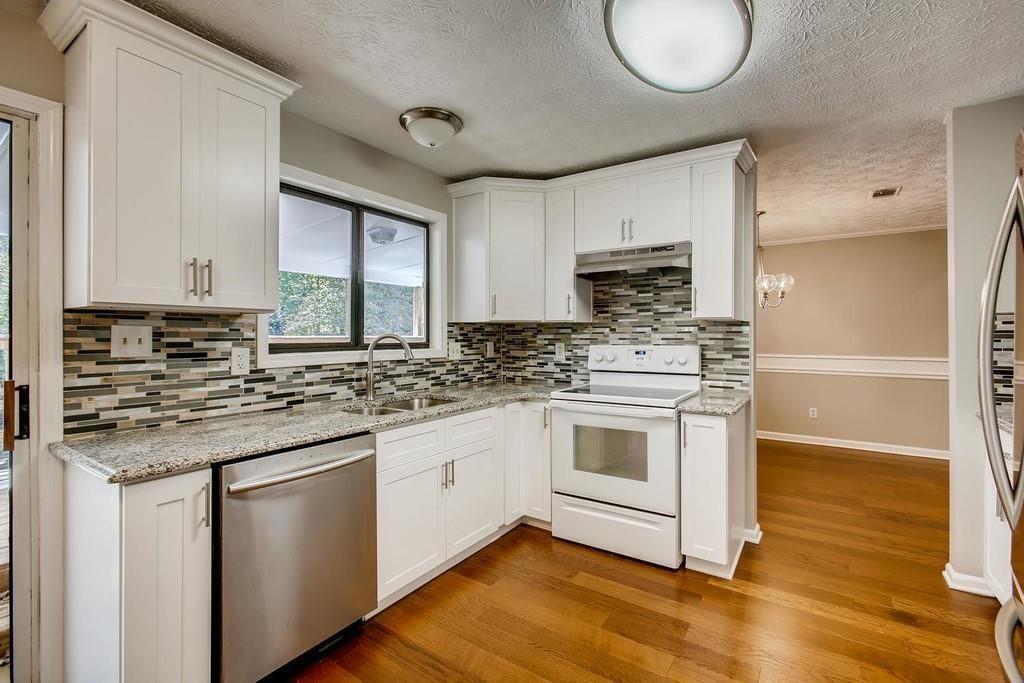 2274 Turtle Landing Marietta, GA 30066 - Photo 24 of 28 a kitchen with stainless steel appliances granite countertop a sink a stove a refrigerator and island with wooden floor