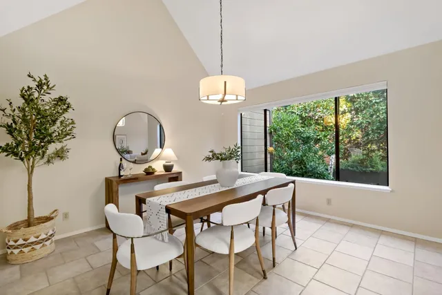 a dining room with chandelier and wooden floor