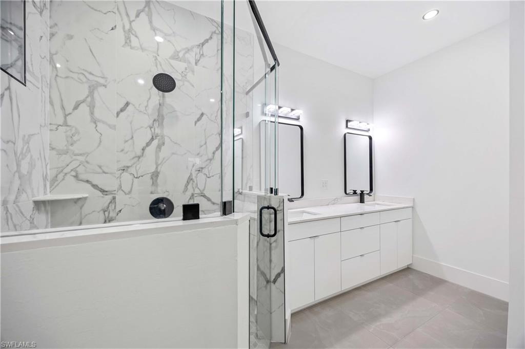 3908 Sunset Road Lehigh Acres, FL 33971 - Photo 19 of 30 a bathroom with double sink and mirror