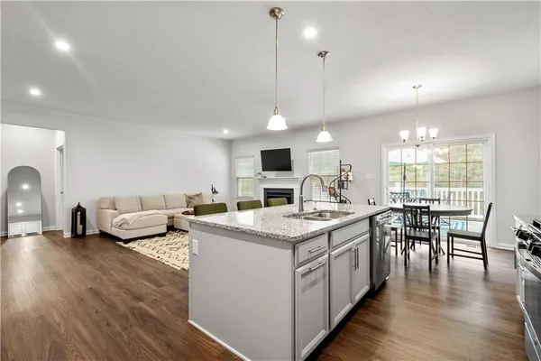 a open kitchen with stainless steel appliances granite countertop a stove and a wooden floors