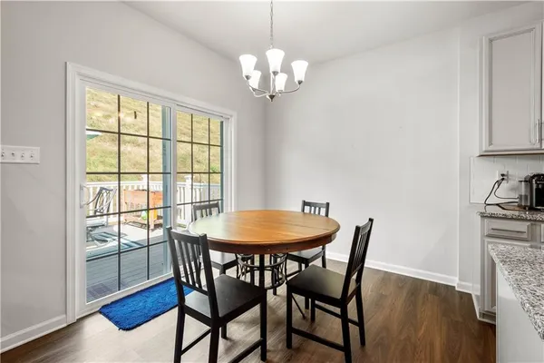 a dining room with furniture a chandelier and wooden floor