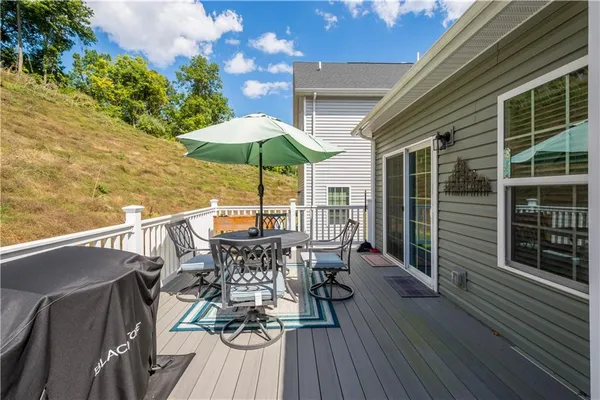 a view of deck with furniture and barbeque oven with wooden floor
