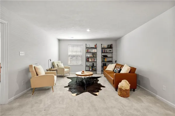 a living room with furniture and a book shelf