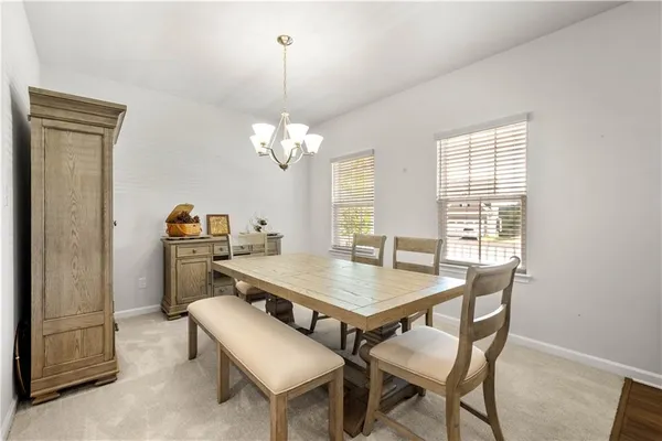 a view of a dining room with furniture and a chandelier