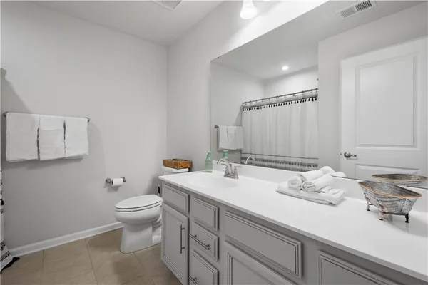 a bathroom with a granite countertop sink mirror and toilet