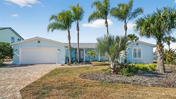 a front view of house with yard and palm tree