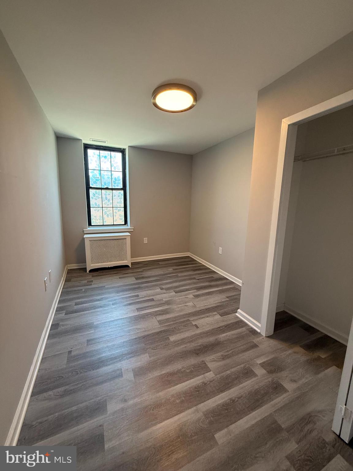 1208 Mifflin Street, Unit 2 Philadelphia, PA 19148 - Photo 9 of 14 an empty room with wooden floor and windows