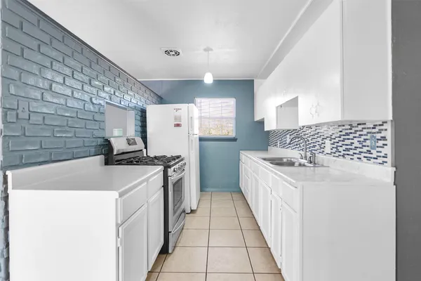 a kitchen with a sink stove and refrigerator