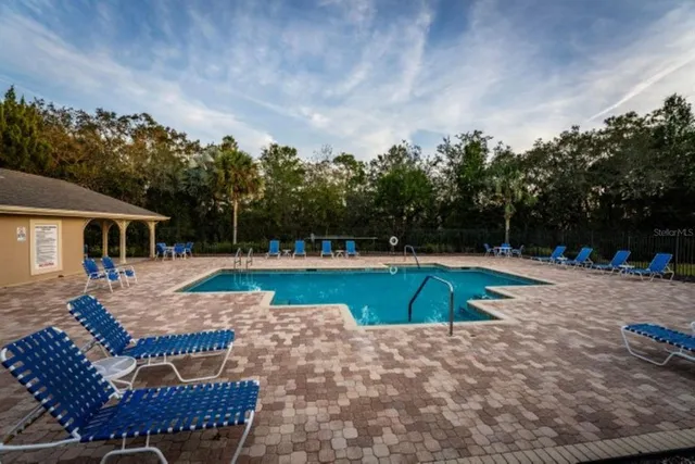 a view of a swimming pool with a patio and a yard