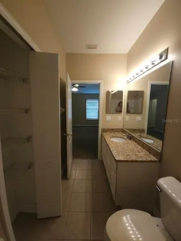 an empty room with a ceiling fan and window