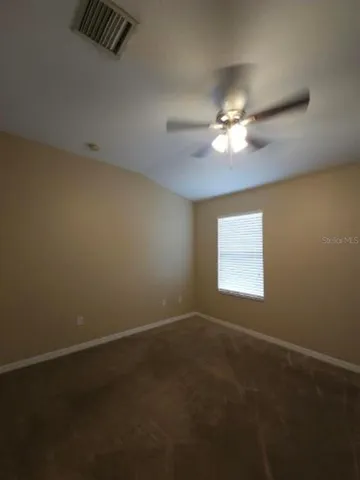 a view of a room with a ceiling fan and bathroom