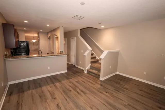 a view of a kitchen with wooden floor and electronic appliances