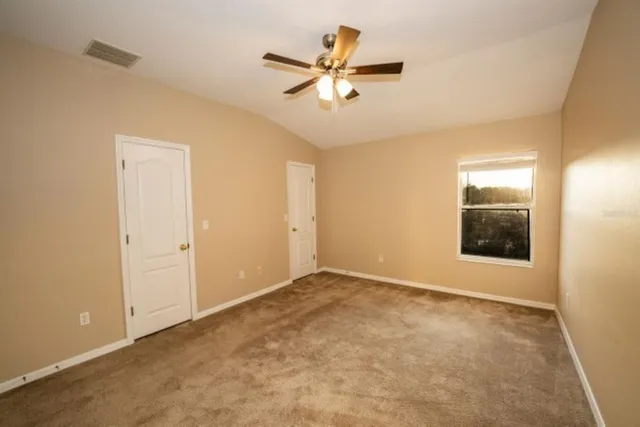 an empty room with closet and fan