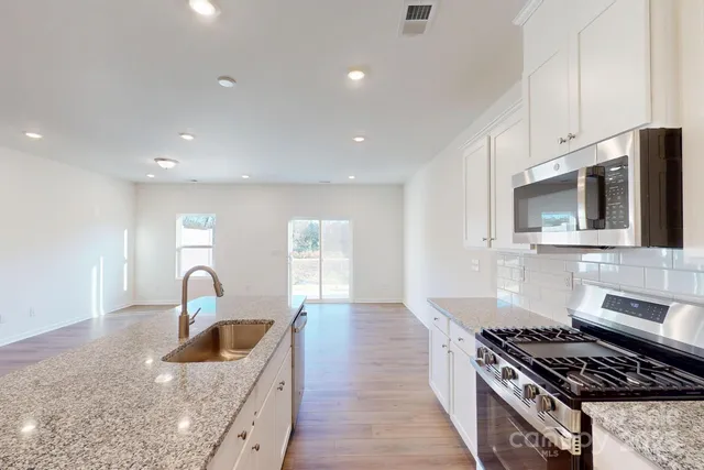 a kitchen with granite countertop a stove and a sink