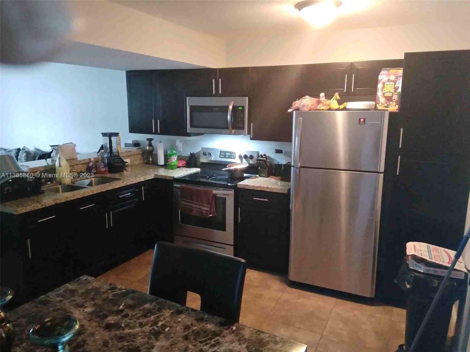 1968 Northwest 4th Court, Unit 323 Miami, FL 33136 - Photo 2 of 12 a kitchen with a sink stainless steel appliances and refrigerator