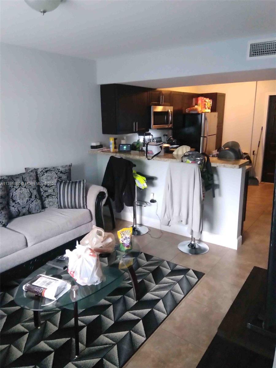 1968 Northwest 4th Court, Unit 323 Miami, FL 33136 - Photo 4 of 12 a living room with furniture and a flat screen tv