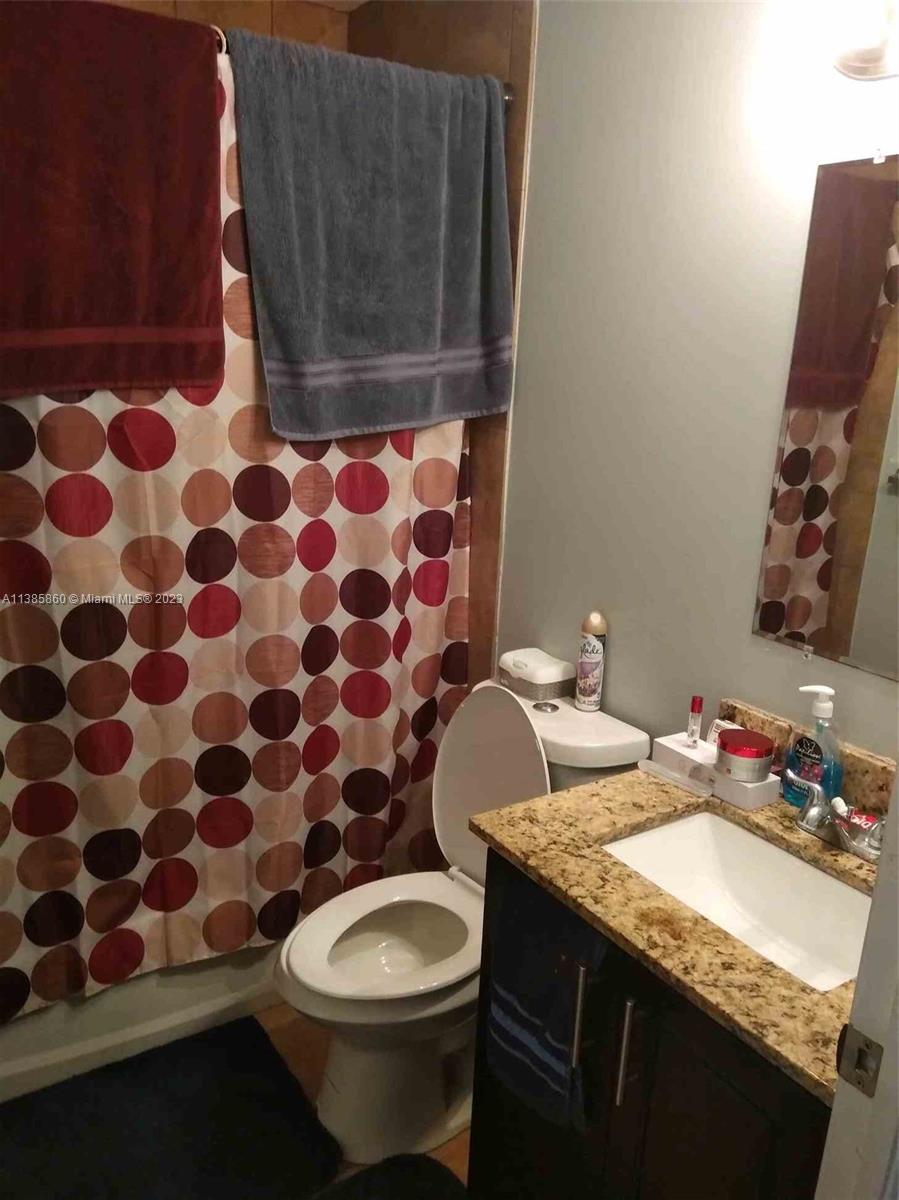1968 Northwest 4th Court, Unit 323 Miami, FL 33136 - Photo 9 of 12 a bathroom with a granite countertop sink and a mirror