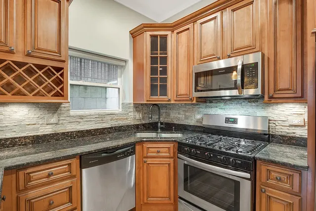a kitchen with stainless steel appliances granite countertop a stove microwave and cabinets