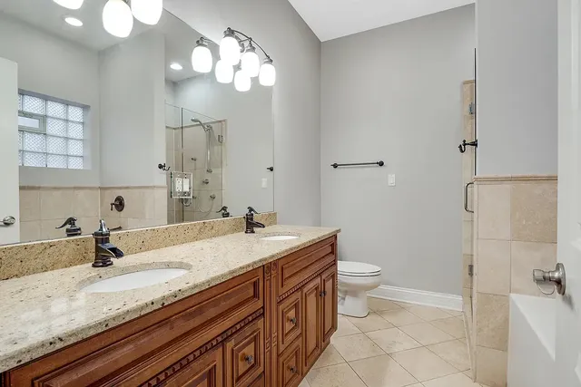 a bathroom with a granite countertop sink a toilet and bathtub