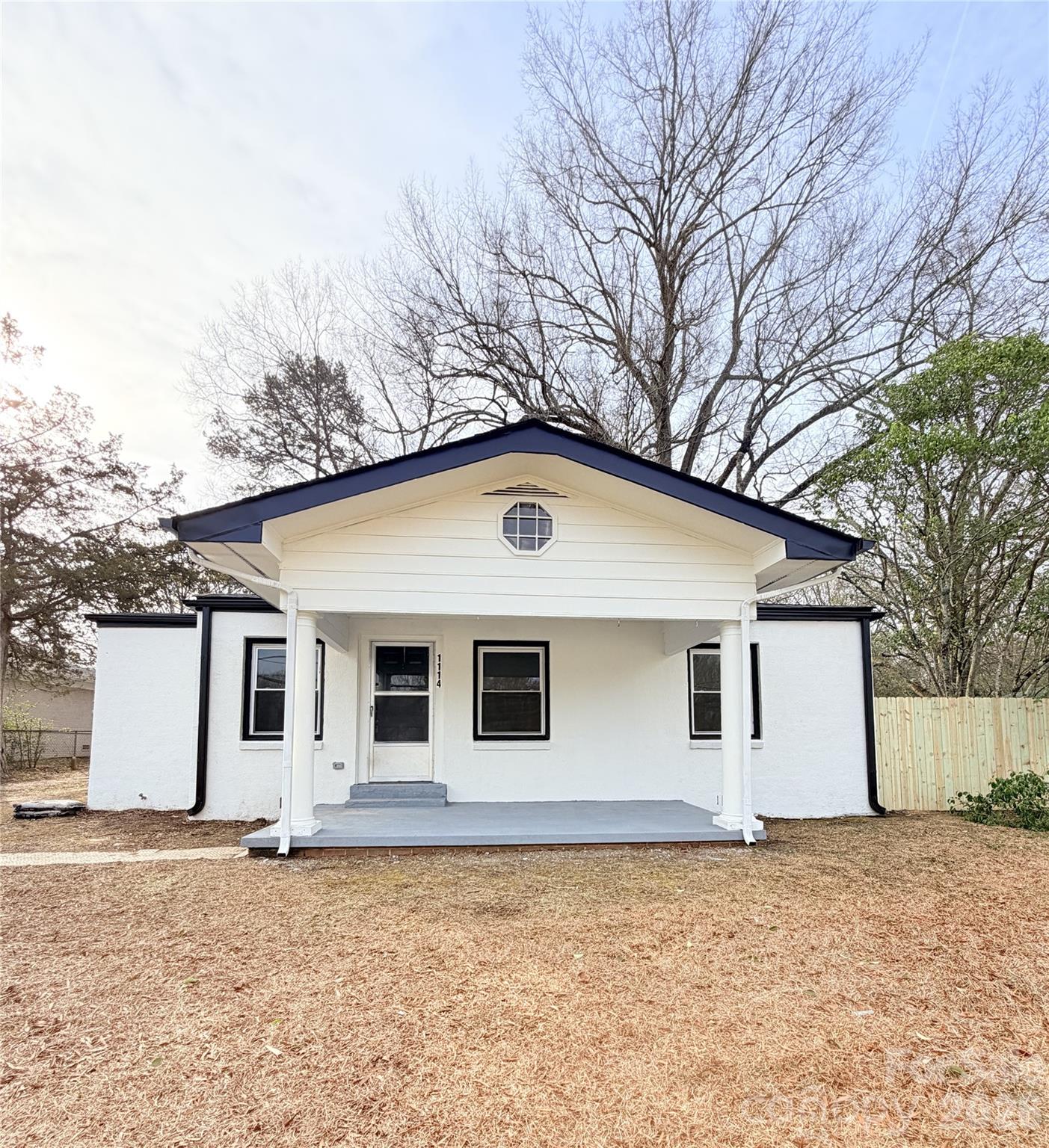 a backyard of a house with large trees and garage