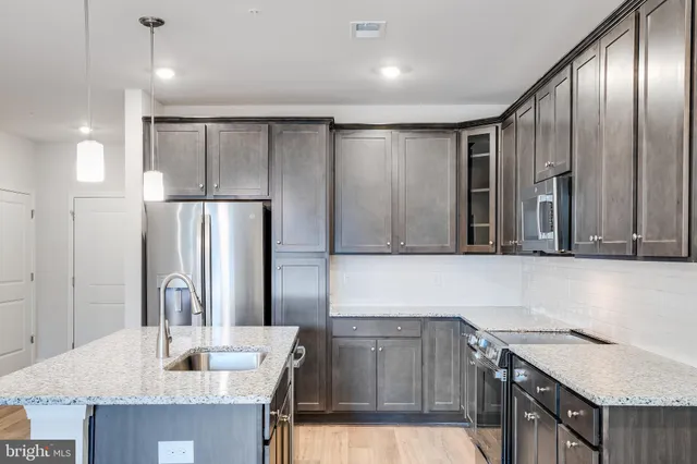 a kitchen with stainless steel appliances granite countertop a sink refrigerator and microwave