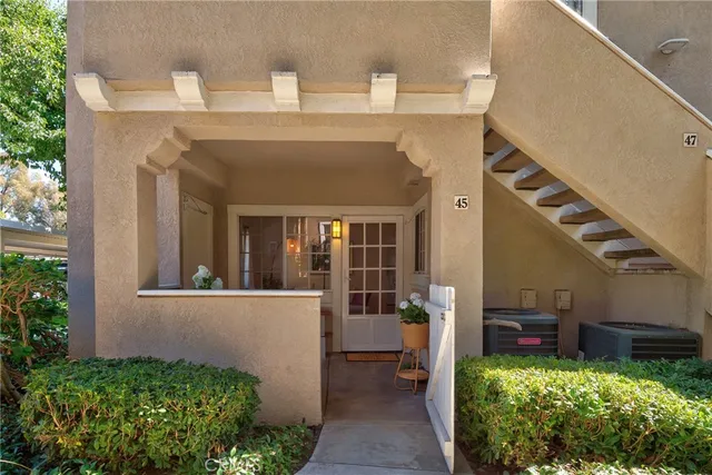 a view of a house with a small yard and potted plants