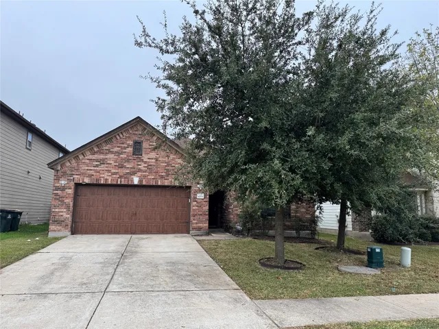 a front view of a house with a yard and trees