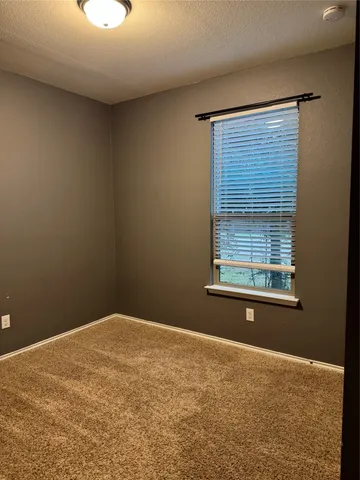 a view of a room with a exposed radiator down to a window