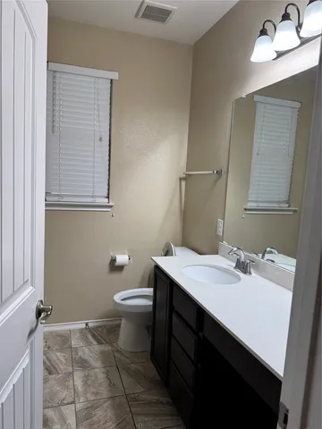 a bathroom with a sink a toilet and mirror