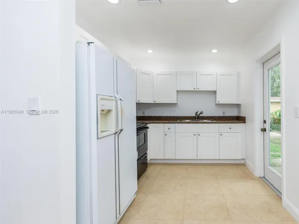 a kitchen with cabinets and a refrigerator