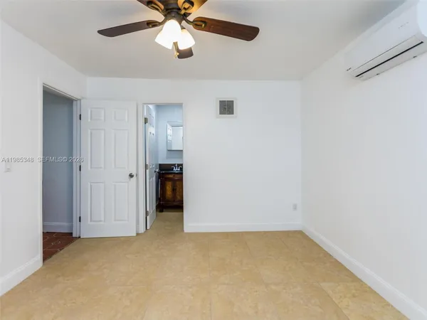 an empty room with closet and a chandelier fan