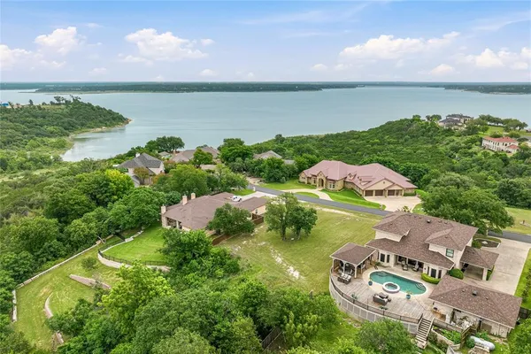 an aerial view of residential houses with outdoor space and lake view