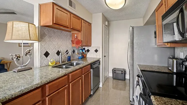 a kitchen with stainless steel appliances granite countertop a sink dishwasher stove and cabinets