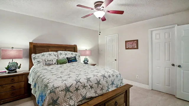 a bedroom with a bed and a ceiling fan